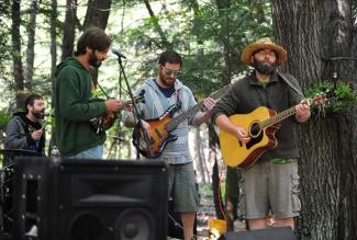 Michael Rosteck playing guitar in the woods, most likely in Michigan somewhere